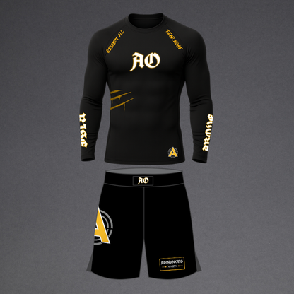 A black long-sleeve athletic compression shirt and matching black shorts set with gold and white graphics, displayed on a neutral gray background.